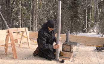freshly built Alaskan log cabin walls under blue sky, snow on ground