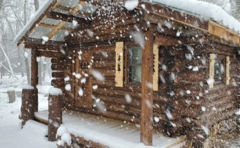 Snowy log cabin in off-grid wilderness during a solo overnight bushcraft stay